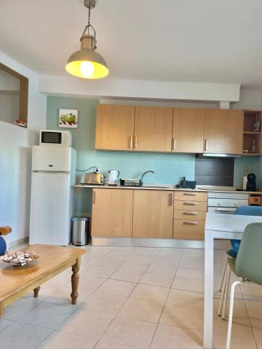 a kitchen with a white refrigerator and wooden cabinets at Bayview Apartment 106 in Albufeira