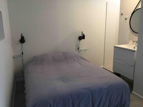 a small bedroom with a bed and a sink at Le logis de Niort Appart Hôtel Le bis in Niort