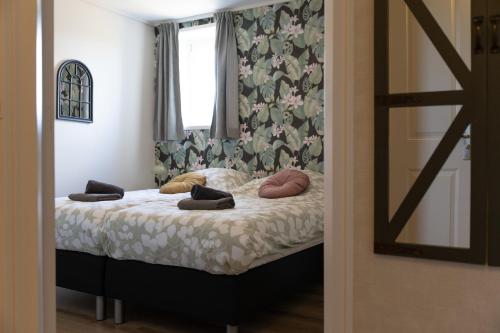 a bedroom with a bed with pillows and a window at In de Zeeuwse Schuur in Biggekerke