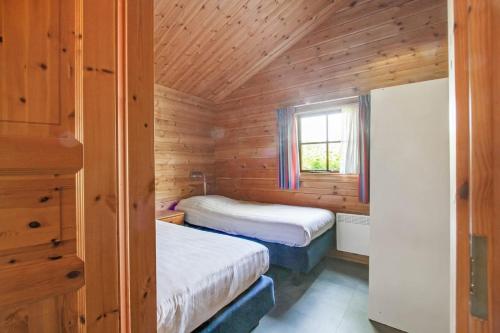 a bedroom with two beds in a wooden cabin at The Nordic Retreat in Gramsbergen