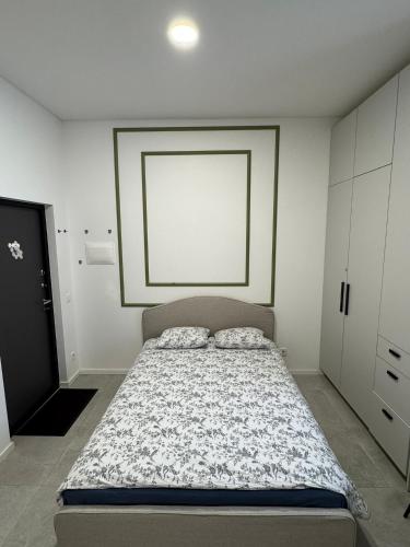 a bedroom with a bed and a white wall at 16 Airport Apartment in Vilnius