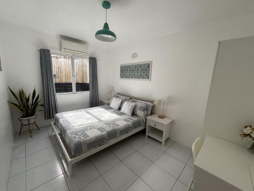 a bedroom with a bed and a window at The Barkly House Staycation in Biñan