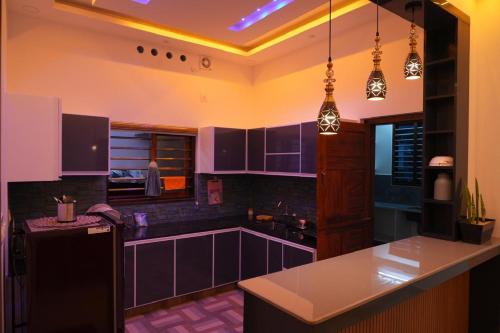 a kitchen with purple cabinets and a black refrigerator at pathayil villa in Thekkady