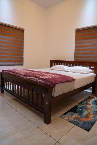 a bedroom with a large bed with a wooden frame at pathayil villa in Thekkady