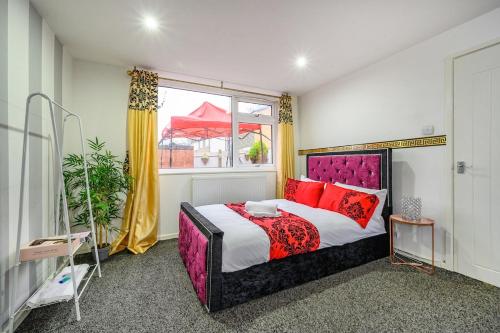 a bedroom with a bed with red pillows and a window at RC10O Satisfying and Spacious stay in Central Station