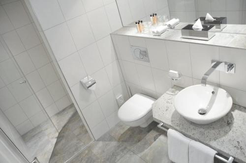 
a white toilet sitting next to a sink in a bathroom at ADELANTE Boutique Hotel in Berlin
