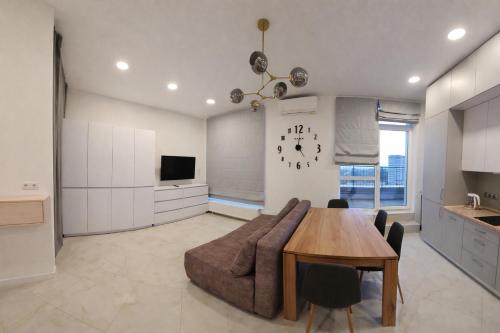 a living room with a couch and a table and a clock at ApartPlus - Затишні апартаменти in Dnipro