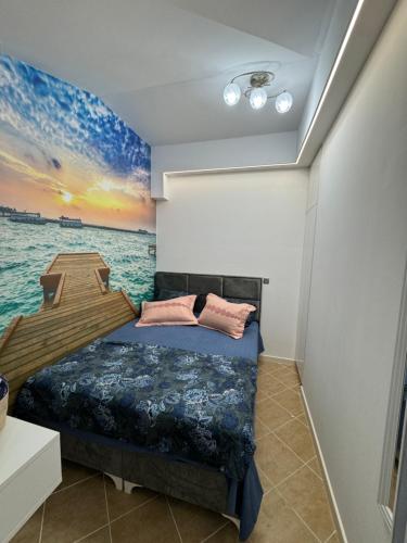 a bedroom with a bed and a painting of the ocean at Apartman Sunce in Budva