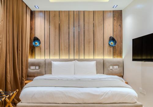 a bedroom with a large bed with a wooden headboard at Rooks Rest Inn & Apartments in Lagos