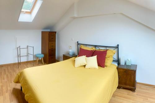 a bedroom with a large yellow bed with red pillows at City centre with lake view in Neuchâtel
