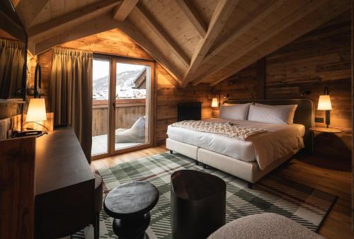 a bedroom with a bed and a window in a cabin at Mont Chalet Nevada - Hotel & Spa in Livigno