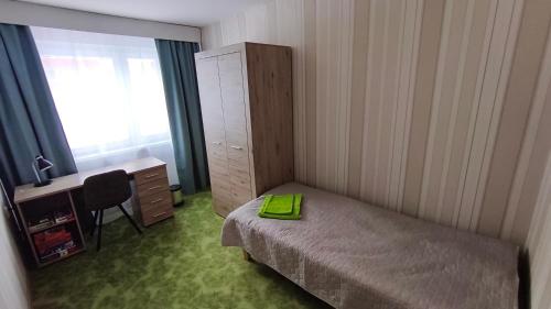 a bedroom with a bed and a desk and a window at Vilde Apartment in Tallinn