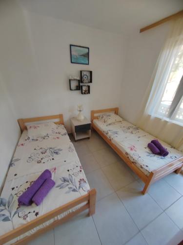 a bedroom with two beds and a window at Apartman Marinamar in Utjeha