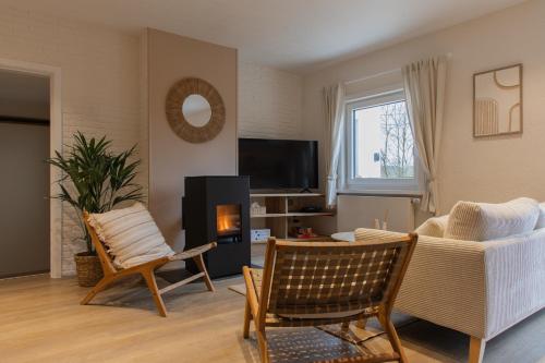 a living room with a couch and a tv at Escapade Boisée in Vencimont