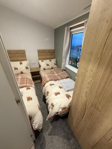 two beds in a small room with a window at The Ellerton at Eyemouth in Eyemouth