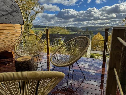 two chairs sitting on a deck with a view at Escapade Boisée in Vencimont