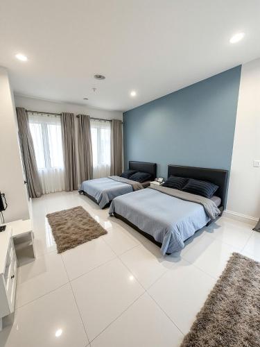 two beds in a bedroom with a blue wall at Kamar Musafir MMS in Ipoh