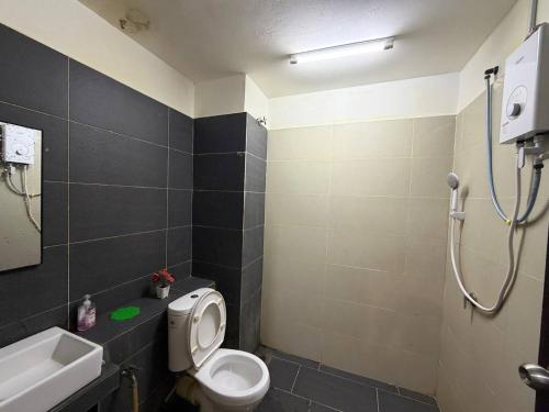 a bathroom with a toilet and a sink and a shower at D'Anggun Studio in Gua Musang
