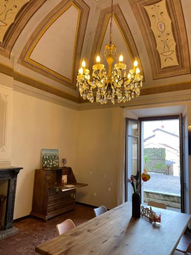 a dining room with a table and a chandelier at Once upon a time in Domaso