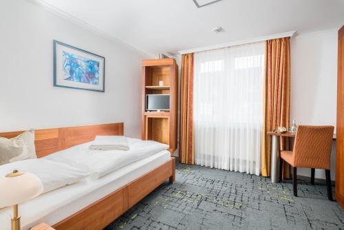 a bedroom with a large bed and a window at BB Landhotel Hütter in Meschede