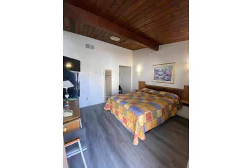 a bedroom with a bed and a desk in a room at Santa Fe Motel Tehachapi by Hotel O in Tehachapi