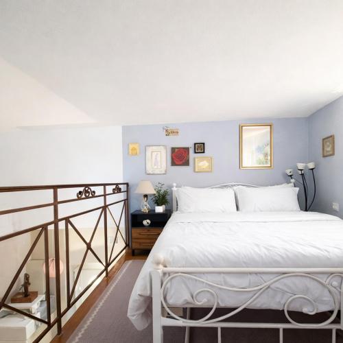 a bedroom with a white bed and blue walls at Azure Loft in Rodhiá