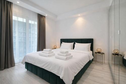 a bedroom with a large bed with white sheets at Aurora Premium Cosmopolis in Tunari