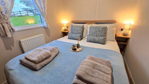 a bedroom with a large bed with towels on it at Cornwall Caravan Retreat 3 Crantock in Crantock