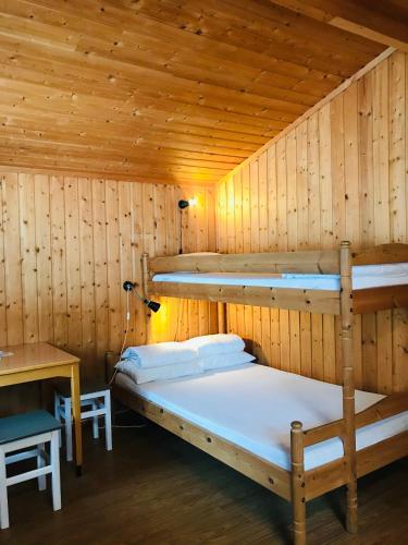 a room with two bunk beds in a wooden cabin at Sæteråsen Hytter & Camping Trysil in Trysil