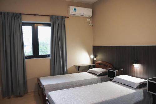 a hotel room with two beds and a window at Hotel Haití in San Miguel de Tucumán
