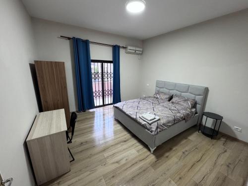 a bedroom with a bed and a wooden floor at Hostel Villa EFES Private Rooms in Tirana