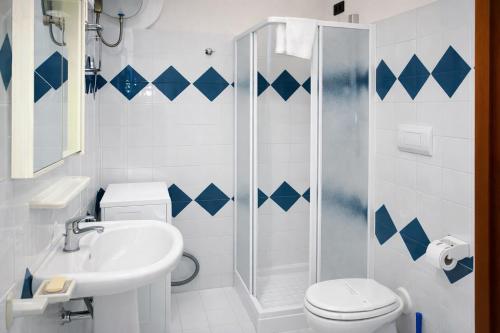 a bathroom with a shower and a toilet and a sink at Residence Oasi Anfiteatro in Porto Ottiolu
