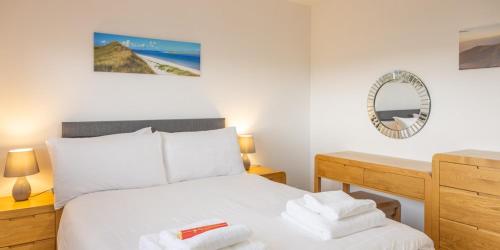 a bedroom with a bed and a desk with a mirror at Self Catering Accommodation - Balivanich, Sleeps 6 in Balivanich