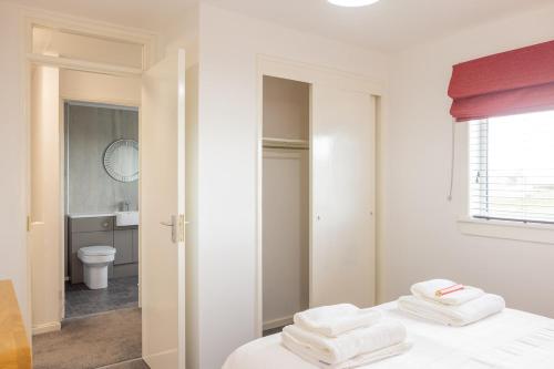 a white bedroom with white towels on a bed at Self Catering Accommodation - Balivanich, Sleeps 6 in Balivanich