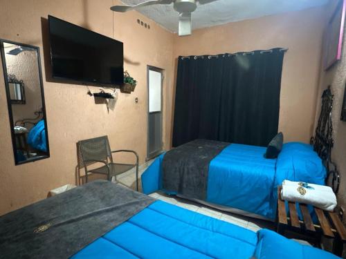 a bedroom with two beds and a couch and a flat screen tv at Hotel Los Reyes in Córdoba