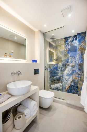 a bathroom with a sink toilet and a shower at Euphoria Boutique Hotel in Chrysi Ammoudia