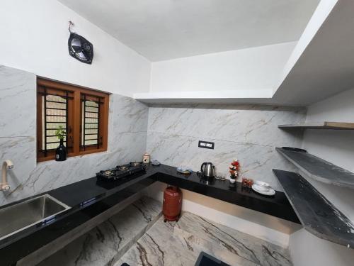a kitchen with a counter top and a sink at Brooklyn Homestay in Vattavada