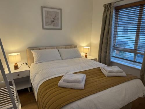 a bedroom with a bed with two towels on it at Vyn's Holiday home - Sleeps 6 in Cardiff