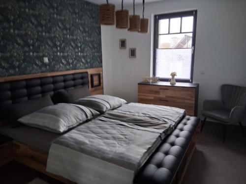 a bedroom with a bed and a chair and a window at Auszeit in Storkow