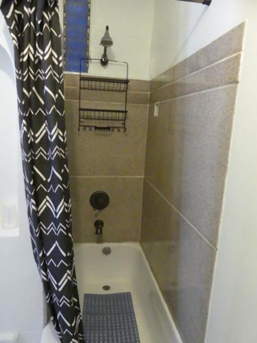 a bath tub with a shower curtain in a bathroom at Wilshire Orange Hotel in Los Angeles
