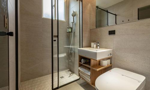 ein Badezimmer mit Toilette, Waschbecken und Dusche in der Unterkunft 雲上太陽villa-KTV烤肉 in Zhixue