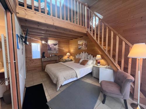 a bedroom with a large bed and a staircase at La Villa Herbert - Piscine chauffée, Spa, Vélos gratuits in Andernos-les-Bains