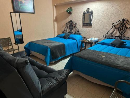 a living room with two beds and a couch at Hotel Los Reyes in Córdoba