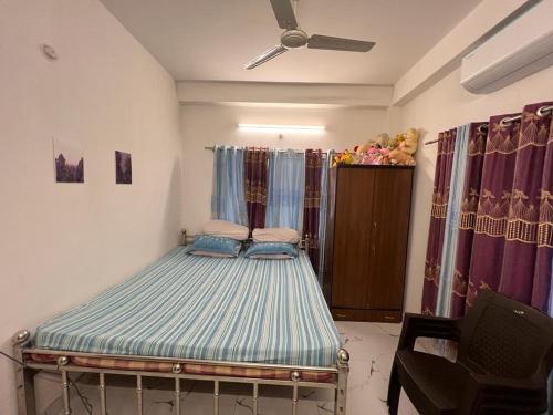 a bed in a room with a ceiling fan at Pappu in Siliguri