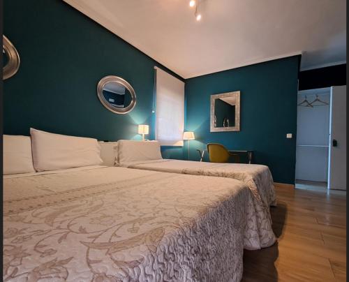 a bedroom with a large bed and a blue wall at C&H Aravaca Garden in Madrid