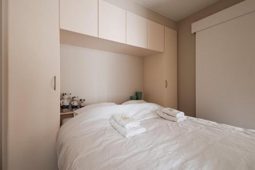a bedroom with a white bed with towels on it at Ground Floor Sea View Apartment in Raversijde, Oostende in Ostend