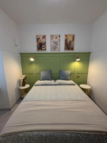 a bedroom with a large bed with a green headboard at Nella Rosa in Monterotondo