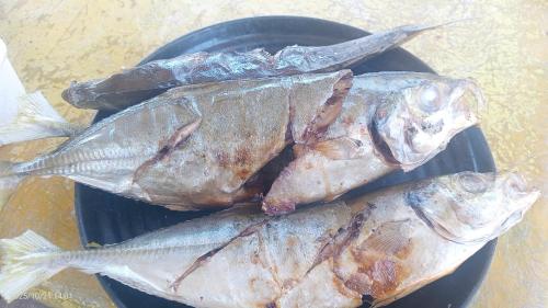 a pile of fish sitting on a black plate at War Homestay in Pulau Minyaifuin