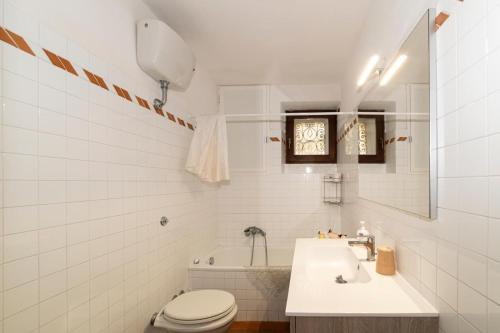 a white bathroom with a toilet and a sink at La Casetta al Corso in Montefiascone