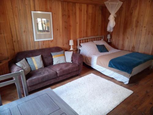 a living room with a bed and a couch at Chalet Banassac in Saint-Ambroix